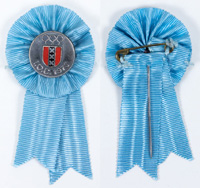 Teilnehmer-Abzeichen 70. IOC Session Amsterdam "I.O.C. 1970". Blaue Stoffrosette und Seidenband. Bronze, versilbert, rot-schwarz emailliert. 7x3,5 cm.<br>-- Schtzpreis: 125,00  --