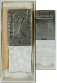 Teilnehmer-Abzeichen der 82. Session I.O.C. Lake Placid 1980. Mit Gravur "Invite C.I.O." (Gast des IOC). Bronze, versilbert mit weiem Seidenbndchen, 11x3,2 cm. In original Verpackung.<br>-- Schtzpreis: 125,00  --