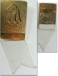 Teilnehmer-Abzeichen der 93e Session I.O.C. Calgary 1988. Bronze vergoldet, mit weiem Seidenband, 9,5x3 cm.