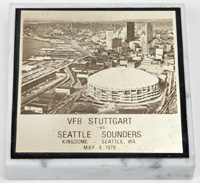 Erinnerungsplakette fr die Spieler des VfB Stuttgart anllich der USA Reise 1978 mit der Aufschrift "VfB Stuttgart vs Seattle Sounders. Kingdome Seattle, May 4, 1978" mit einer Ansicht von Seattle. Messingplakette auf Marmorsockel montiert, 10x10x2 cm.<b